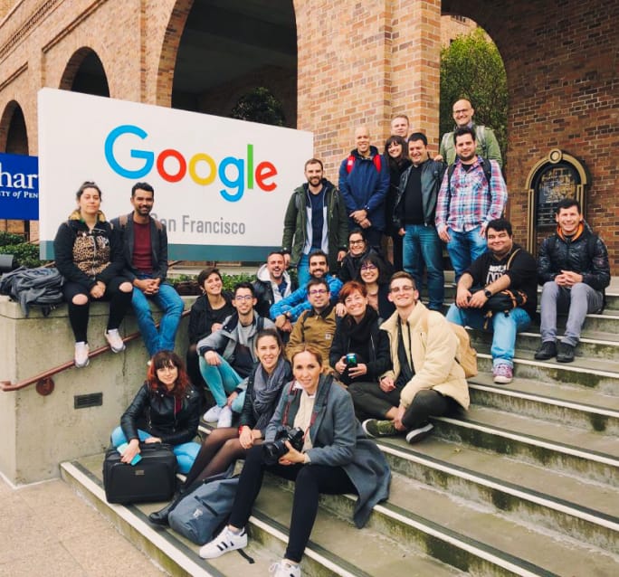 A group of students and teachers posing next to the Google logo in San Francisco