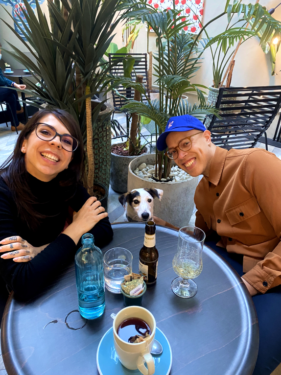 People posing at a table with a dog in between